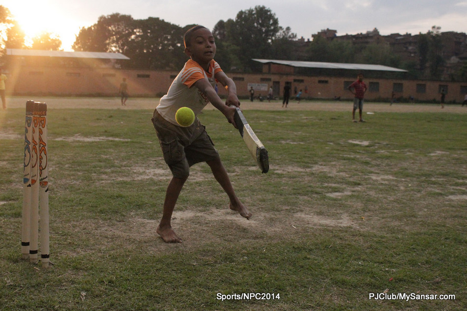 A kid attempts to defend the wickets as he strikes the ball. Photo: Nawa Bijay Shrestha 