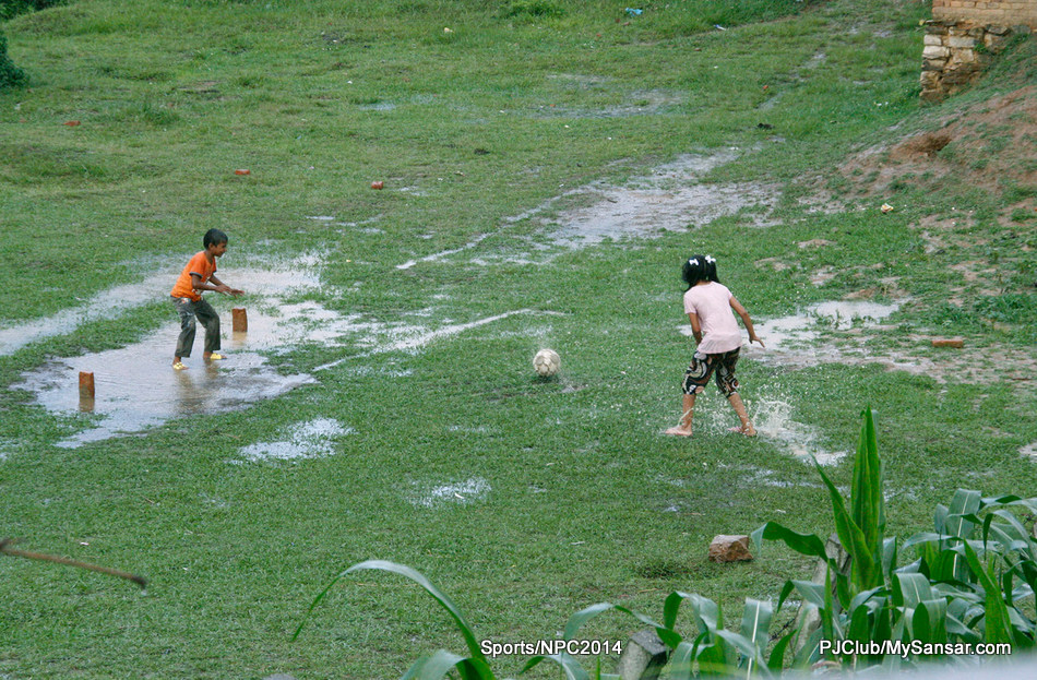 A young girl takes a penalty shot as a young boy readies to defend the makeshift post. Photo: Sajeen Maharjan. 