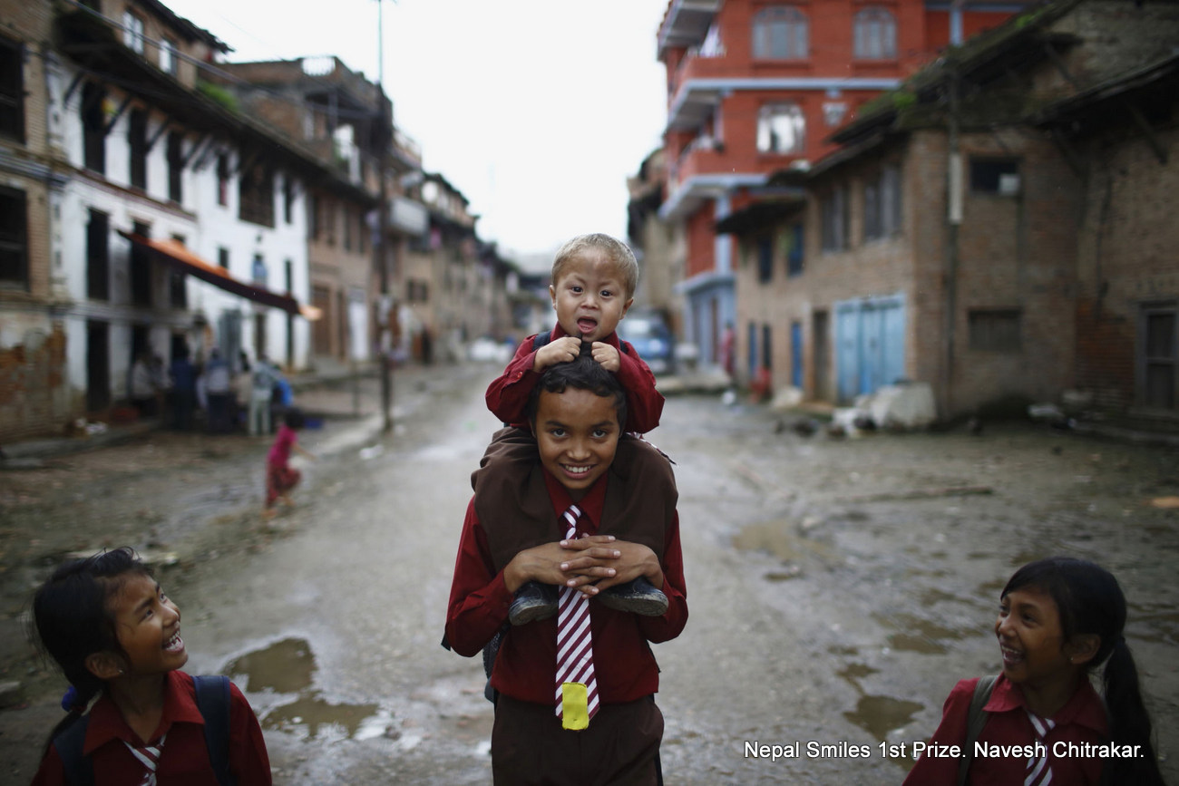 A boy carries a child on his back as they return home from school along the streets of Lalitpur July 2, 2013.