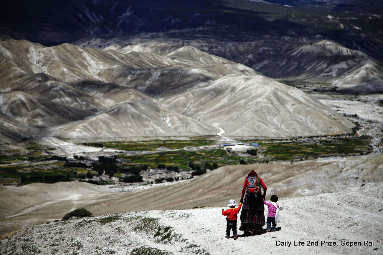 A woman walks with two children as they make their way from Samzong to Lomanthang.Upper Mustang, is a remote and isolated region of the Nepalese Himalayas. The Upper Mustang was a restricted demilitarized area until 1992 which makes it one of the most preserved regions in the world, with a majority of the population still speaking traditional Tibetic languages. Tibetan culturehas been preserved by the relative isolation of the region from the outside world