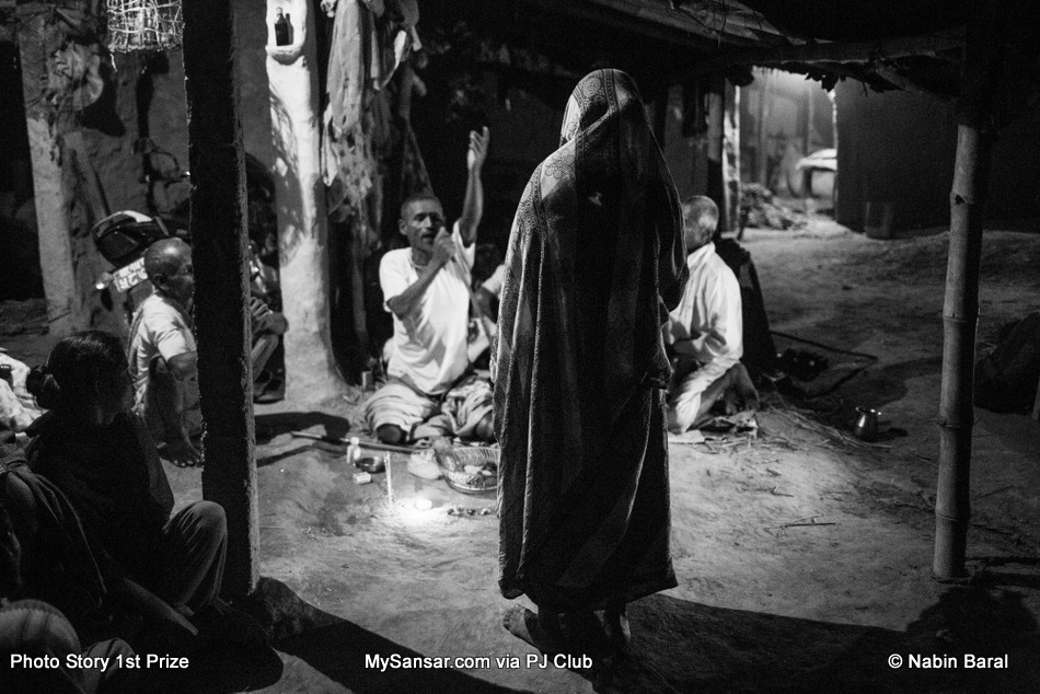 A women visits a Dhami, the night before attending the “Ghost Festival” to eradicate evil spirits or problems created by family god "kul deveta"  supposedly afflicting some of the villagers in Janakpur, a district in Terai region of Nepal. November 4 2014. Janakpur, Nepal.
