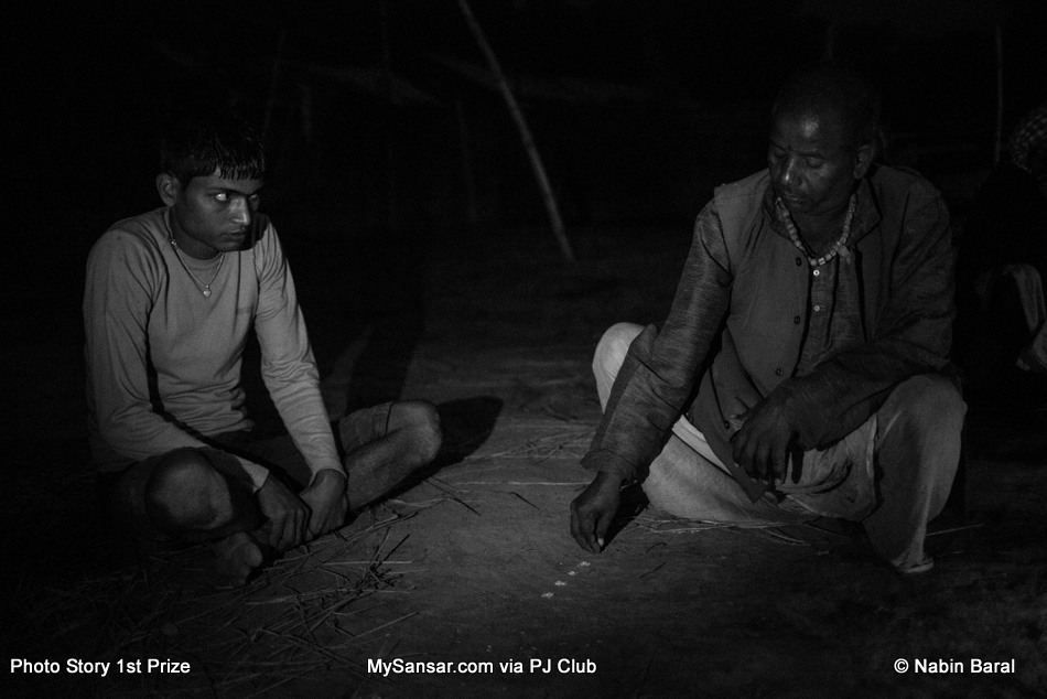A Dhami,  practices divination to determine the reason of 18 year old Brikeah Yadav ‘s headaches, body pain and fainting.  The Dhami accuses Kanti Yadev, 103 year old widow villager, of witchcraft practiced on the young man.  November 5 ,2014, Janakpur, Nepal.
